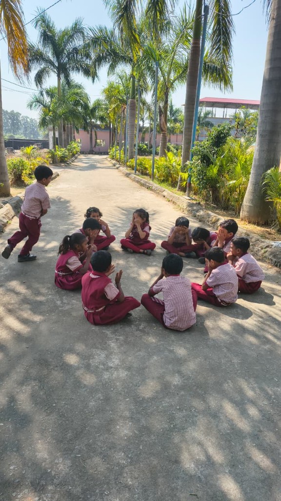 Primary students playing an outdoor circle game on campus